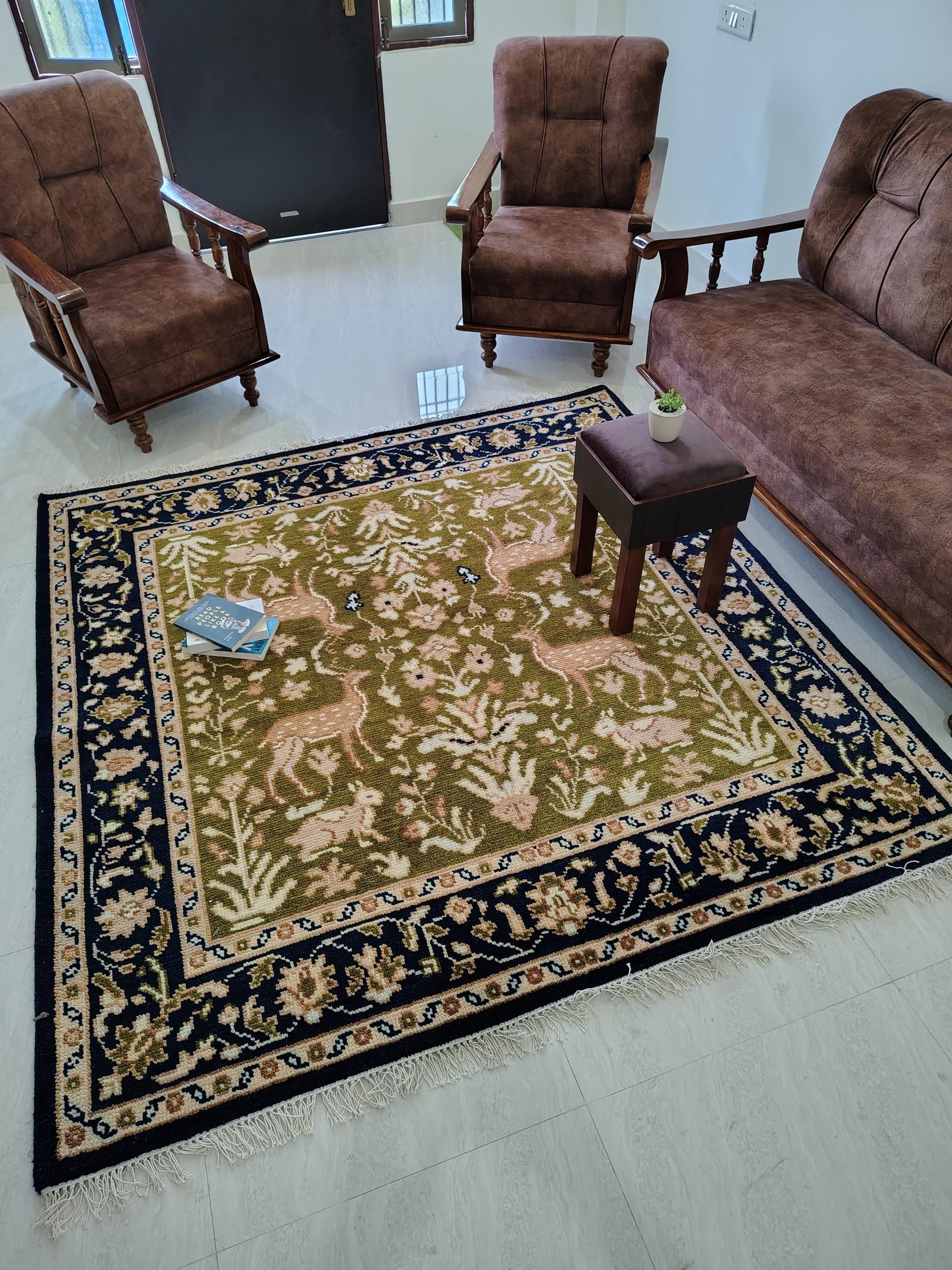 Hand knotted wool rug with Persian animal motifs, green field, navy floral border, traditional living room carpet