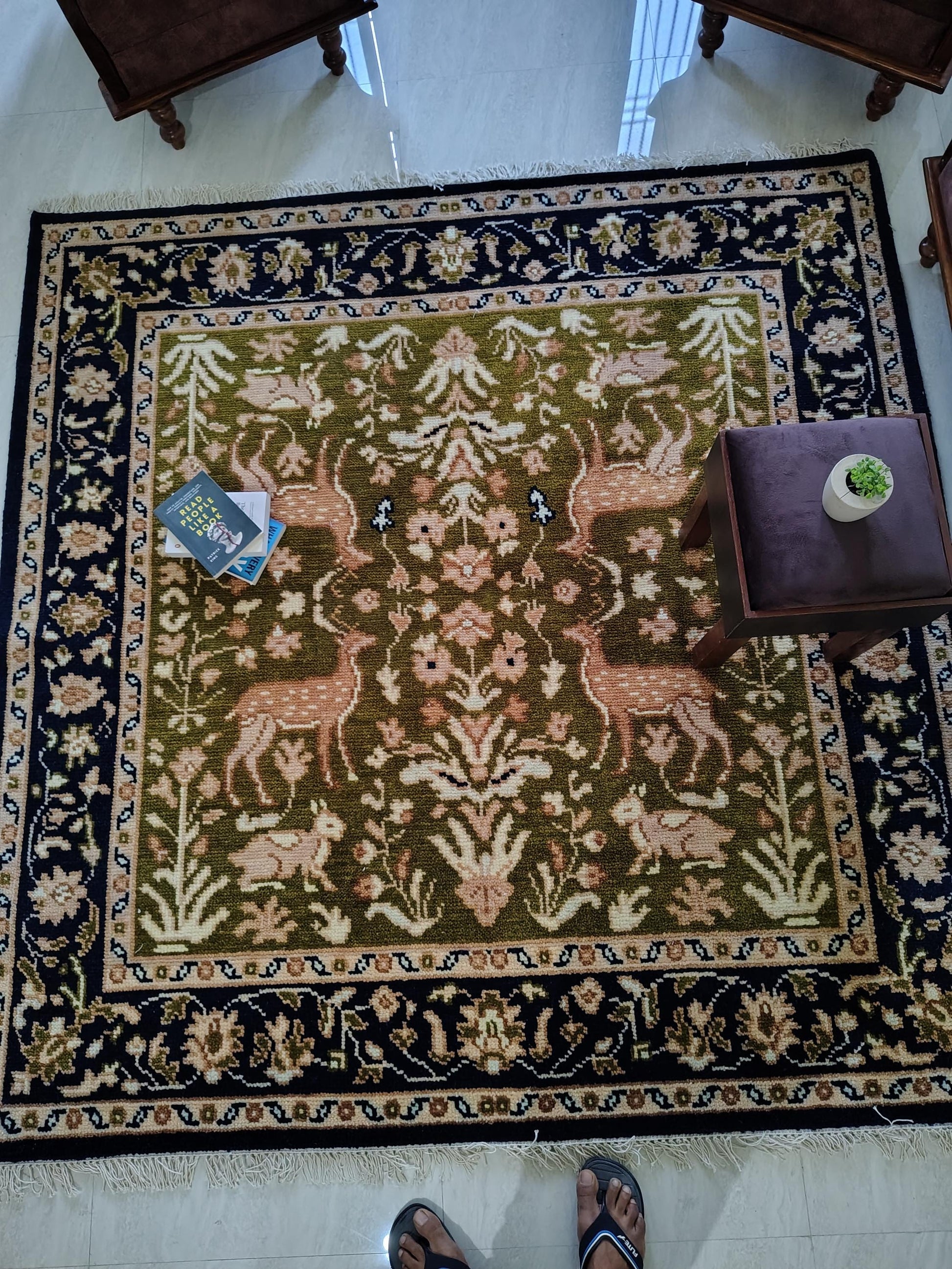 Hand knotted wool rug with green Persian animal motif and navy floral border