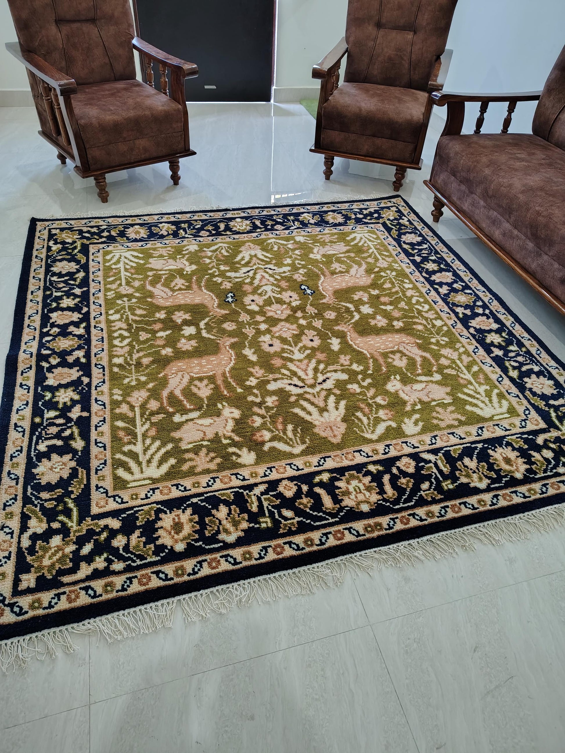 Hand knotted wool rug with green Persian animal motifs and navy floral border