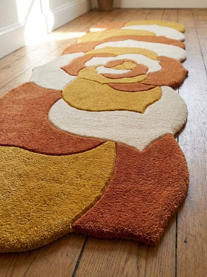 Hand tufted abstract floral runner rug in mustard yellow and burnt orange with irregular shape for modern hallway decor