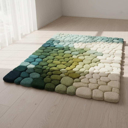 Hand-tufted pebble rug with green, teal, and cream gradient and 3D textured stone design
