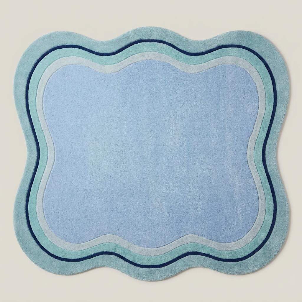 Modern irregular shaped blue carpet with abstract wave edges styled beside a neutral contemporary sofa __etsy:8084463929