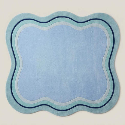 Modern irregular shaped blue carpet with abstract wave edges styled beside a neutral contemporary sofa __etsy:8084463929