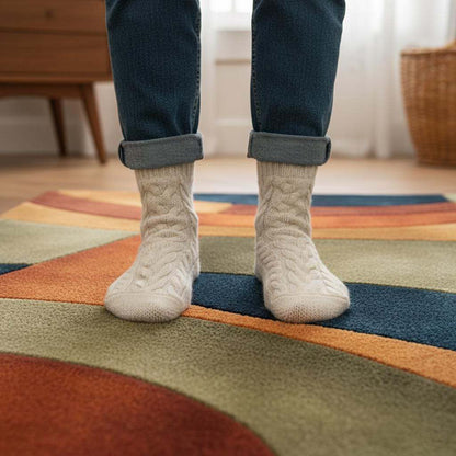 Handmade retro rug with mid century curved geometric pattern in warm 70s tones on wool tufted carpet