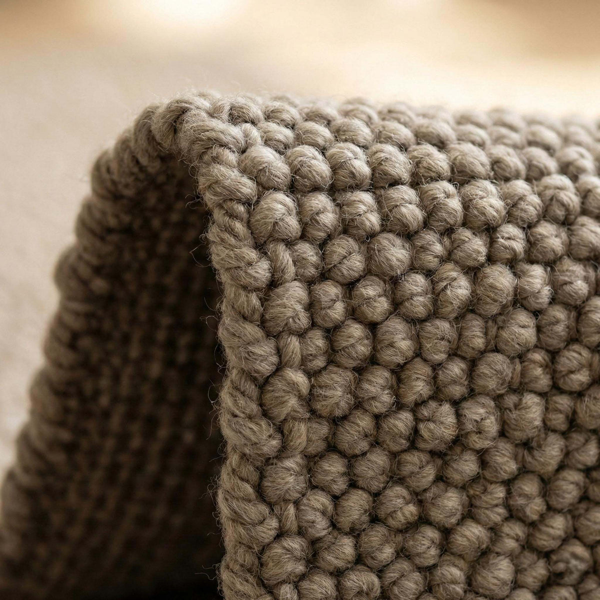 Handmade chunky knit wool rug with neutral color and thick cozy texture for modern minimalist interiors