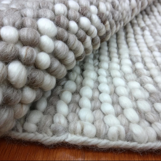 Handmade chunky wool rug with cream and beige pom pom design for cozy, natural home décor