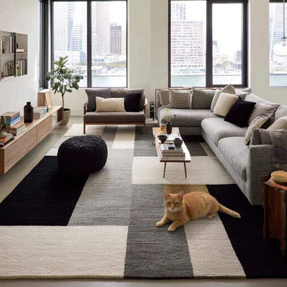 Handmade geometric wool area rug with modern black, gray, and cream block pattern