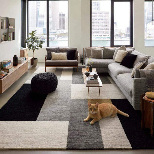 Handmade geometric wool area rug with modern black, gray, and cream block pattern
