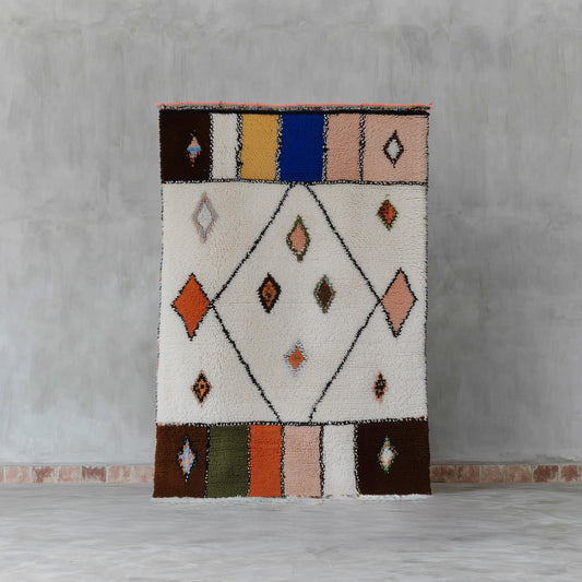 Handmade Moroccan Berber wool rug with cream diamond pattern and colorful geometric accents