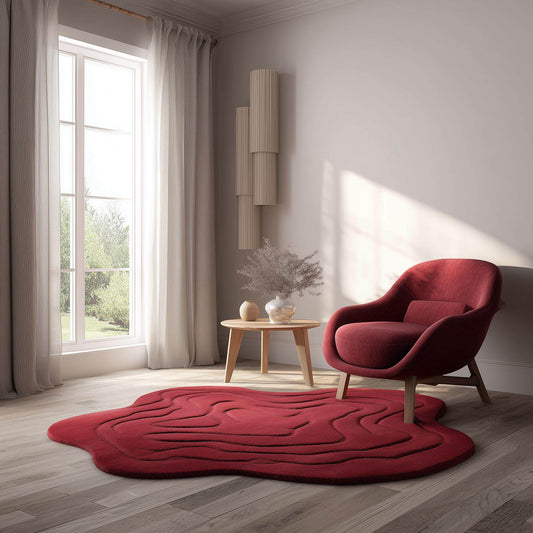 Handmade tufted red rug in modern irregular shape with 3D wave design, styled in a cozy living room with wooden floor, neutral walls, and natural light.