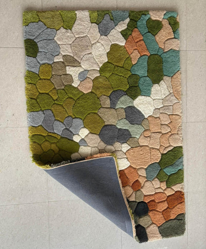 Handmade wool tufted moss rug with nature-inspired forest floor texture and muted floral design