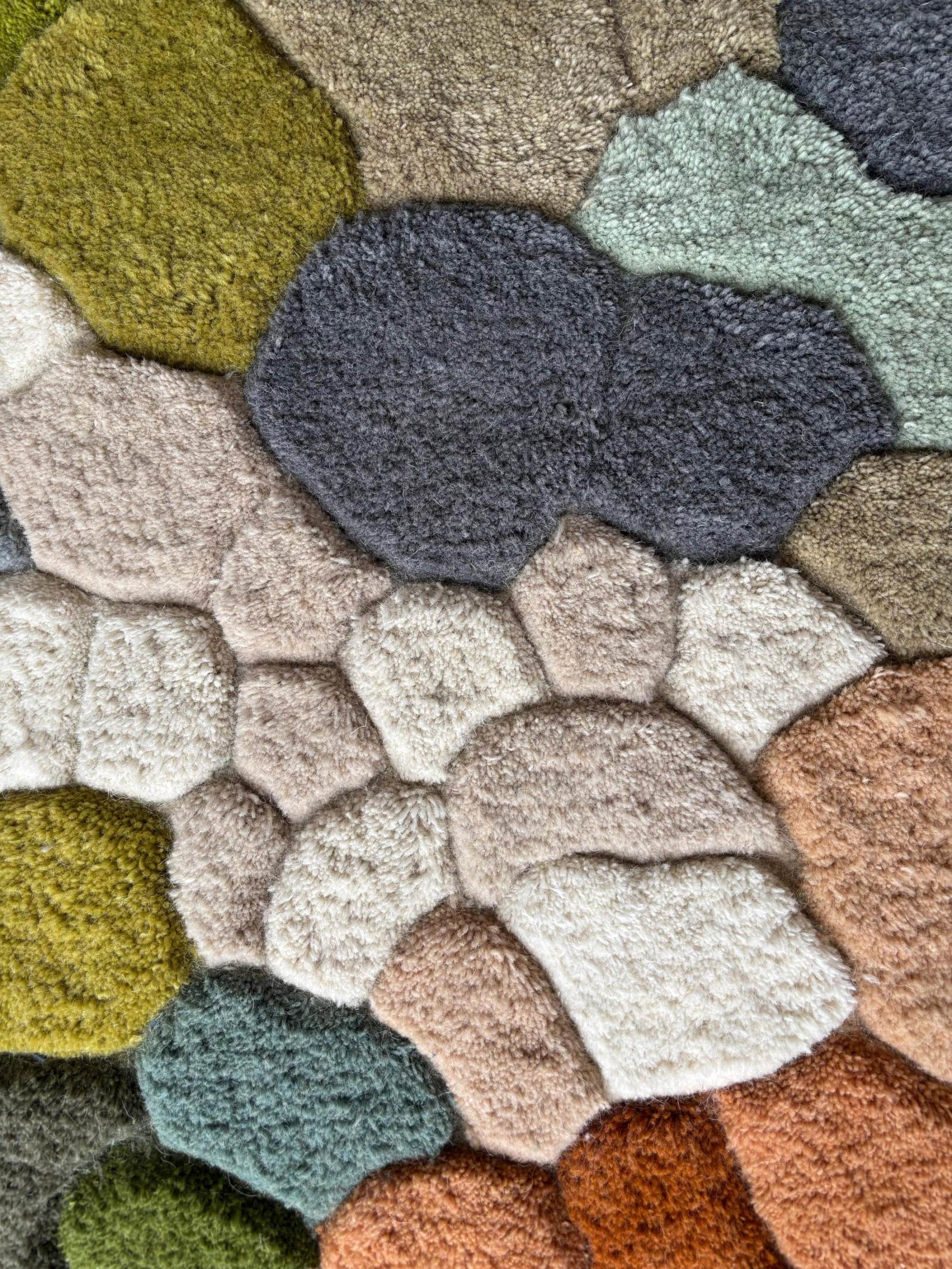 Handmade wool tufted moss rug with nature-inspired forest floor design in muted colors.