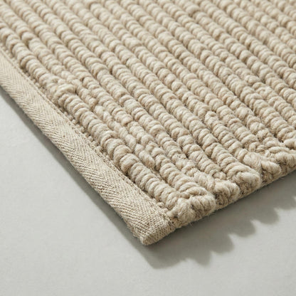 Handwoven chunky wool rug with thick looped weave in neutral beige, perfect for cozy farmhouse and modern interiors
