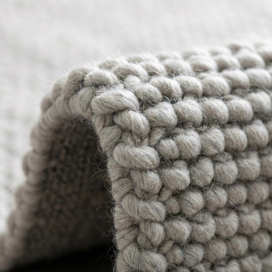 Handwoven chunky wool rug in neutral gray with thick weave for cozy Scandinavian farmhouse decor
