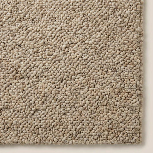 Handwoven chunky wool rug with neutral loop pile in farmhouse style living room