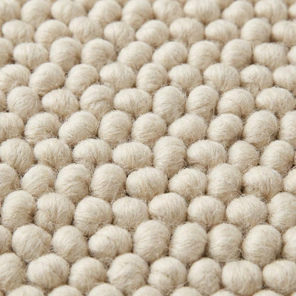 Handwoven chunky wool rug in neutral cream with thick cozy texture for Scandinavian decor