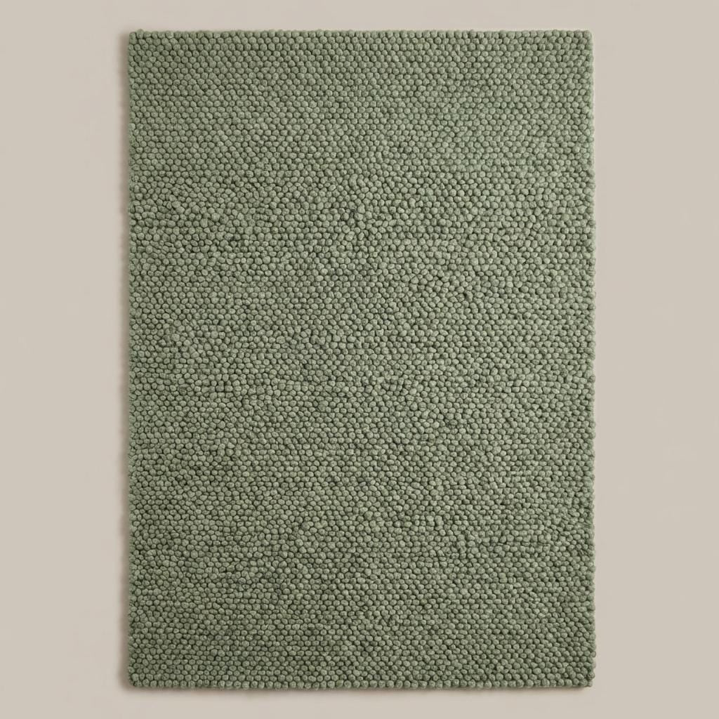 Handwoven chunky wool rug in neutral tones enhancing Scandinavian home decor with soft, thick texture and natural wool fiber.