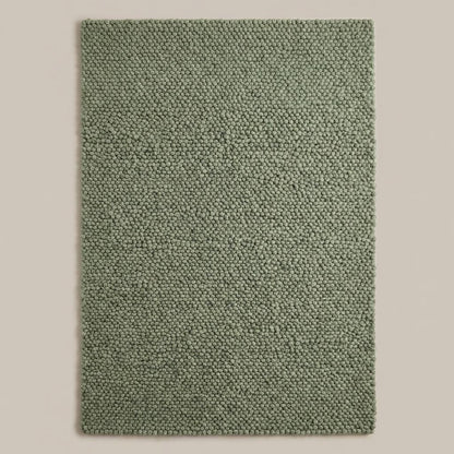 Handwoven chunky wool rug in neutral tones enhancing Scandinavian home decor with soft, thick texture and natural wool fiber.