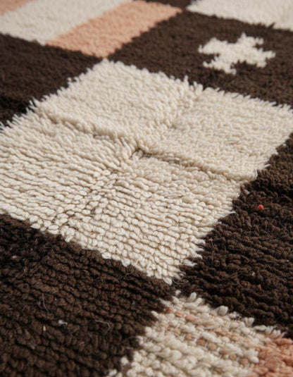 Handwoven Moroccan wool shag rug with cream and chocolate checkerboard pattern and peach accents