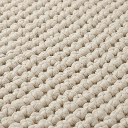Close-up of thick loop pile wool rug showing natural fibers and cozy handmade construction
