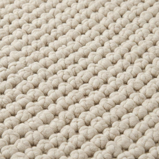 Close-up of thick loop pile wool rug showing natural fibers and cozy handmade construction
