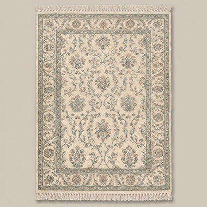 Traditional floral hand knotted rug with cotton fringe on wooden flooring
