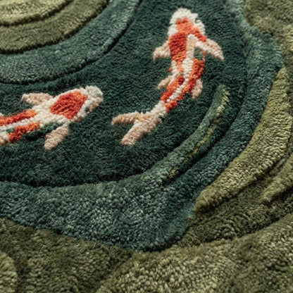 Close-up of dense wool hand-tufted pile showing carved contours, soft looped fibers, and raised koi fish detailing.