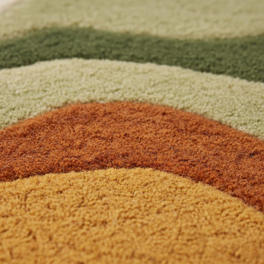 Close-up of plush tufted pile and abstract wave pattern on boho shag rug, ideal living room accent.