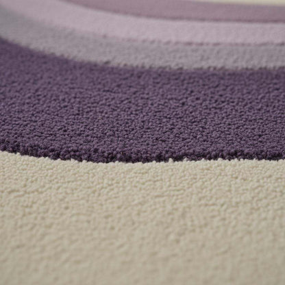 Lavender area rug with modern retro curvy stripe pattern, plush tufted surface, and pastel purple tones for living rooms and bedrooms