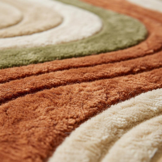 Close-up of hand-tufted wool rug showing plush high-pile texture, dense fibers and carved wavy stripe craftsmanship.