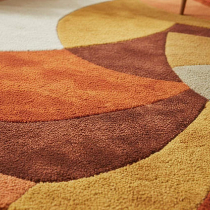 Close view of sculpted high-pile retro rug with abstract curved shapes — mustard, cream, rust tones for mid-century decor.
