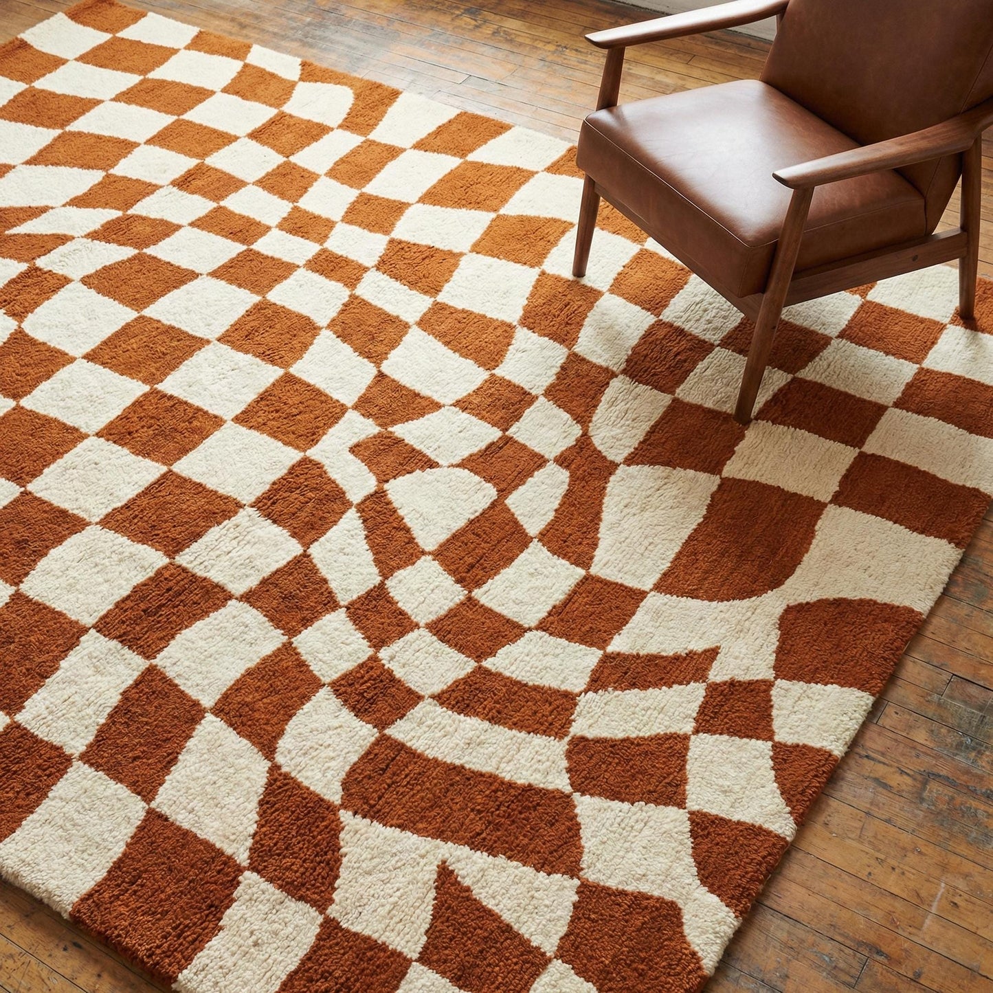 Modern checkerboard wavy tufted rug with warm rust and ivory tones, hand-tufted wool, mid-century geometric pattern, perfect for living rooms and bedrooms.