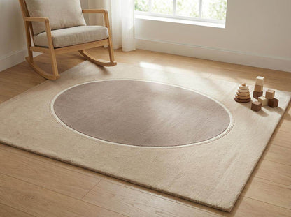Modern neutral oval hand tufted wool area rug with beige and taupe tones in a contemporary living room