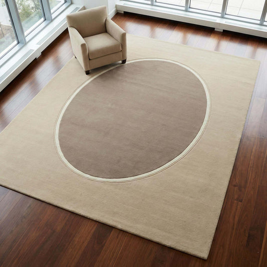 Modern neutral oval hand tufted wool area rug in beige and taupe in a contemporary living room