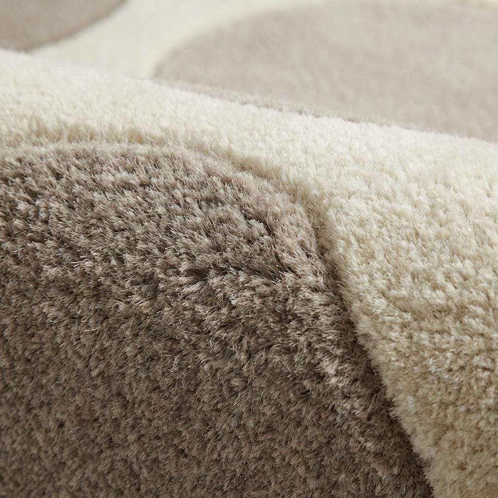 Modern pebble pattern tufted wool area rug with neutral tones in a minimalist living room setting