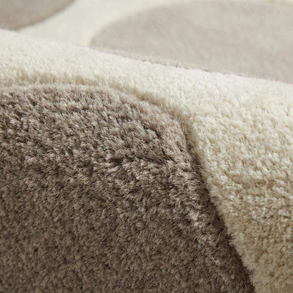 Modern pebble pattern tufted wool area rug with neutral tones in a minimalist living room setting