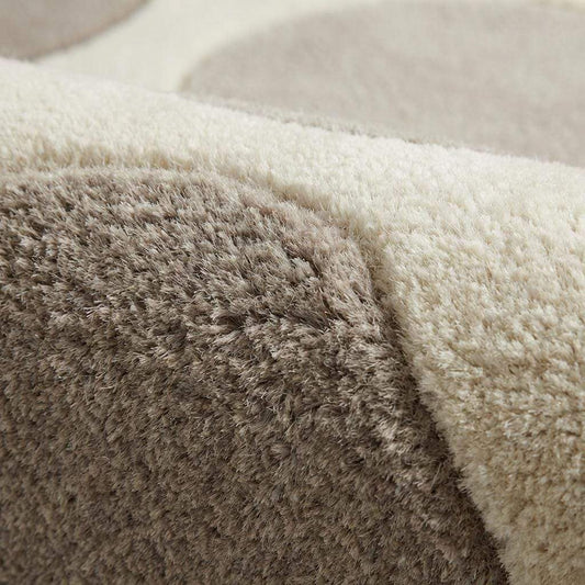 Modern pebble pattern tufted wool area rug with neutral tones in a minimalist living room setting