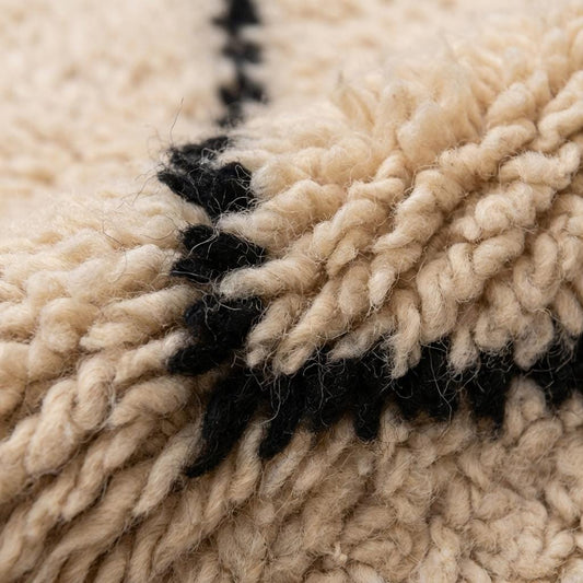 Close up of plush textured ivory rug with charcoal geometric lines