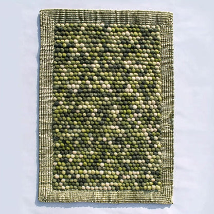 Handmade olive green felt ball rug with chunky wool texture for boho and Scandinavian home décor
