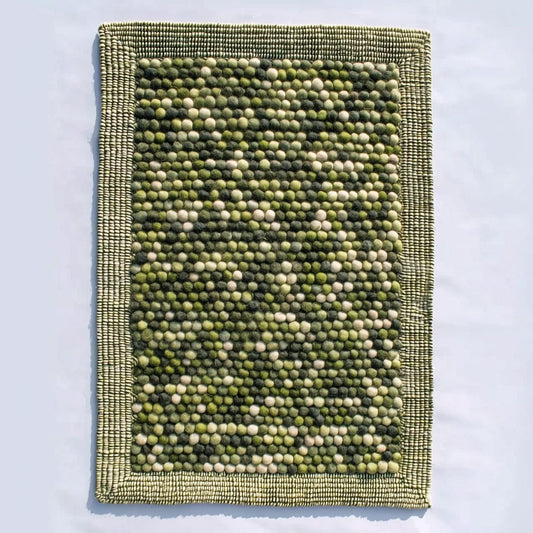 Handmade olive green felt ball rug with chunky wool texture for boho and Scandinavian home décor
