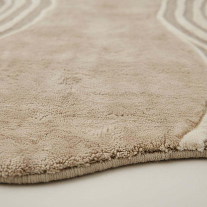 Organic wavy rug with beige irregular shape and soft plush texture for modern minimalist decor