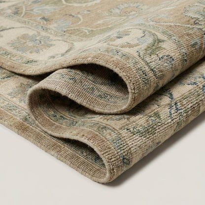 Hand-knotted Oushak floral wool area rug with vintage-inspired design and soft beige and sage-blue tones