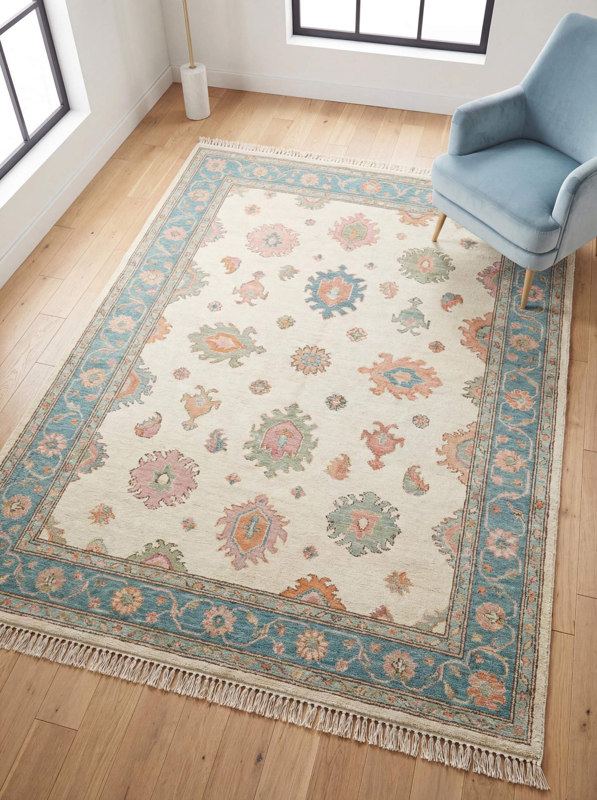 Hand knotted Oushak rug with pastel floral design, soft blue border and beige field in modern living room setting __etsy:7883142190