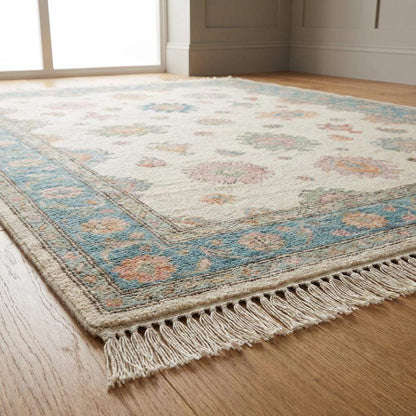 Soft blue and beige Oushak hand knotted rug with floral pastel design in vintage style living room setting