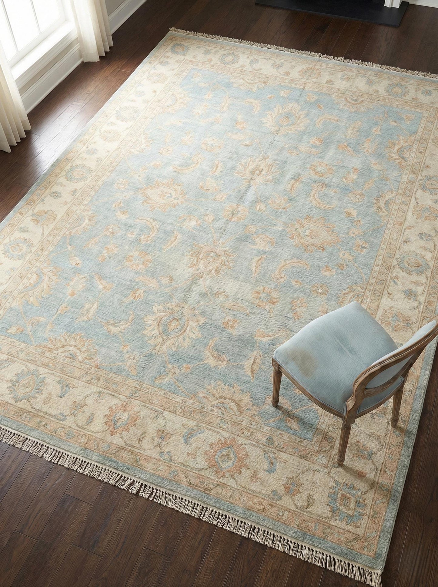 Hand knotted Oushak wool area rug in soft blue with floral border pattern