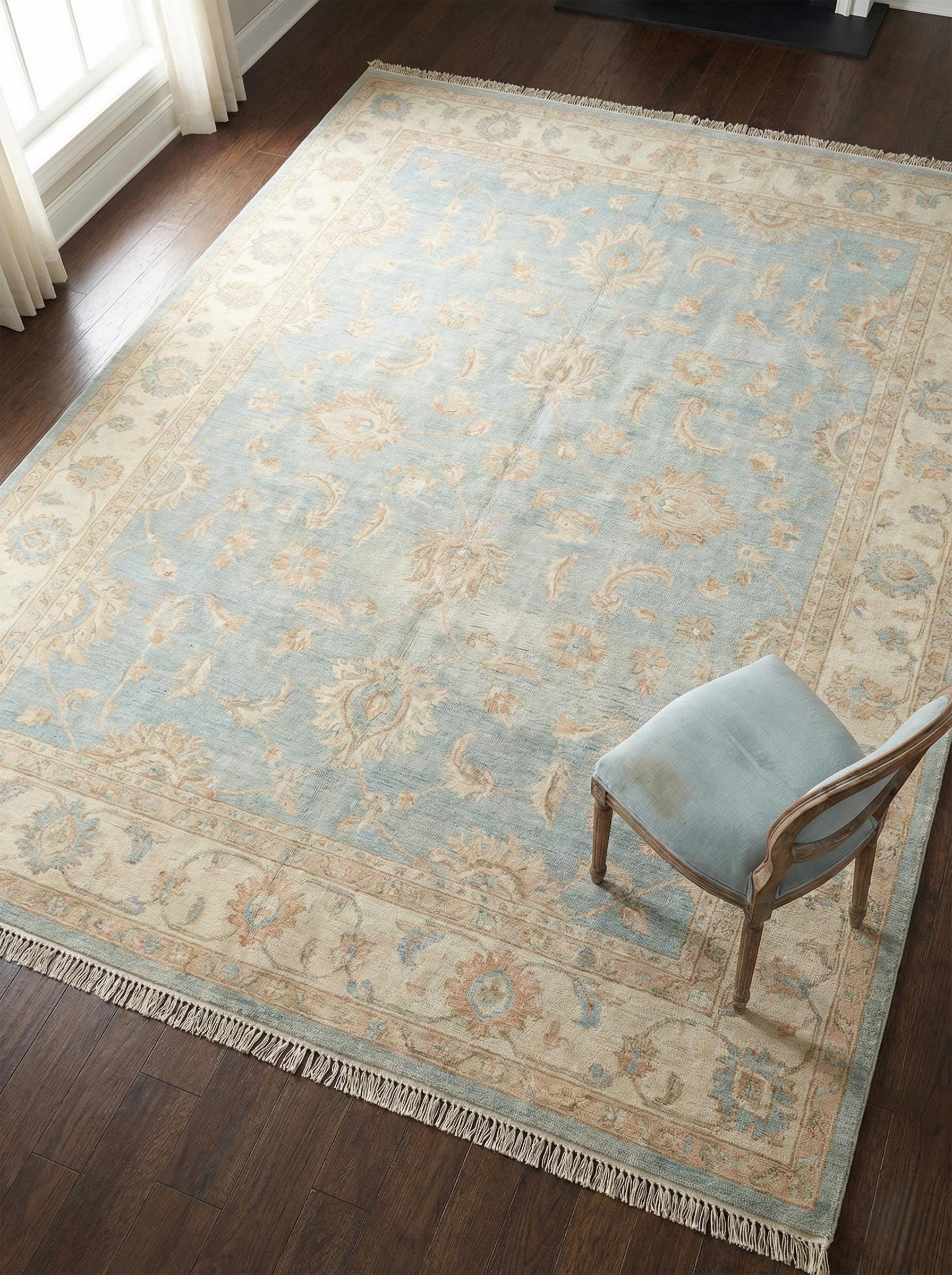 Hand knotted Oushak wool area rug in soft blue with floral border pattern