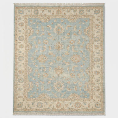 Artisan hand knotted wool rug styled in living room with hardwood flooring