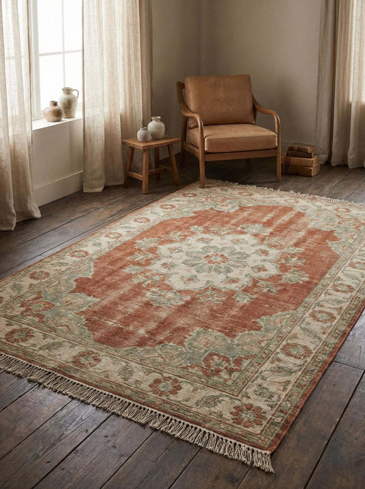 Hand knotted Oushak wool rug with faded floral medallion in terracotta and sage tones