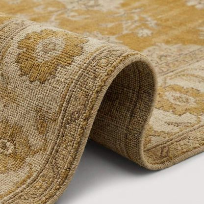 Oushak hand knotted wool rug with mustard floral design in cozy living room setting
