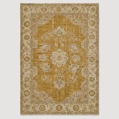 Oushak hand knotted wool rug with mustard floral design in living room setting